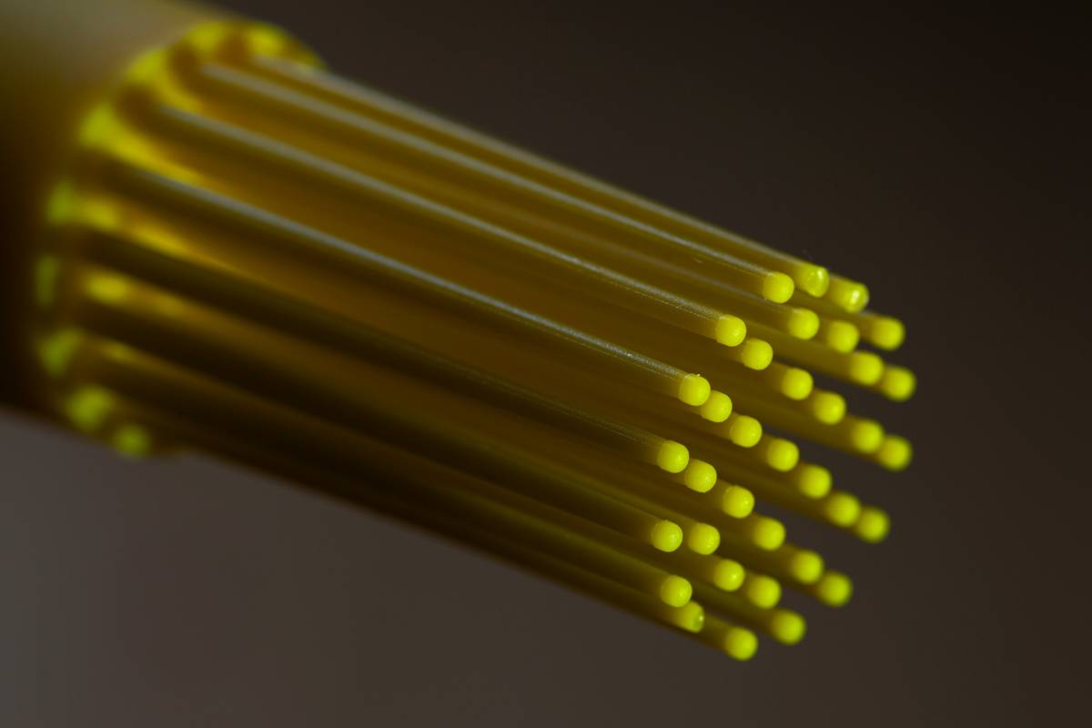 Citrus zester definition illustrated with close-up of tool removing bright yellow zest from lemon peel, no pith visible